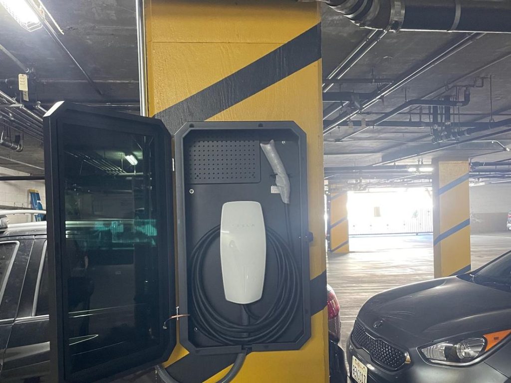 A charger mounted on a garage wall near the panel