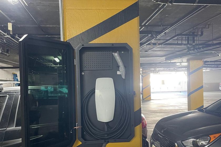 A charger mounted on a garage wall close to the electrical panel